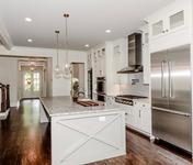 Modern Farmhouse style Kitchen open to Breakfast & Family Room in this Chamblee, GA custom home by Waterford Homes